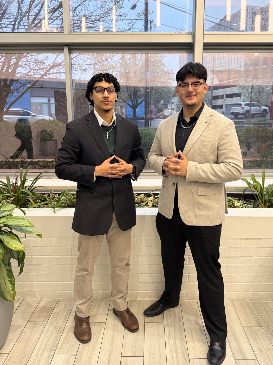 Two Risin Enterprises team members in business attire at the office