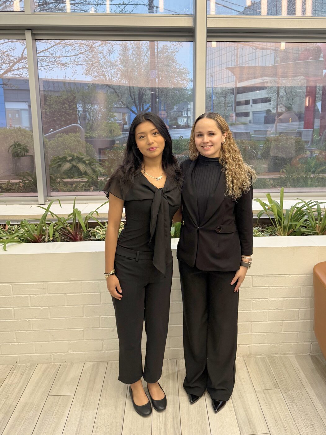 Two Risin Enterprises team members in professional attire at the office